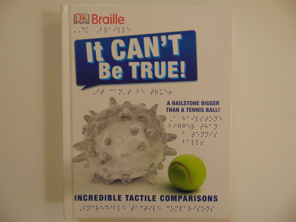 Image Description:  front cover with white background, “DK” with an outline of a book around it and “Braille” in red print and the braille translation underneath in the top left corner,  at the top in a blue speech bubble, words in white print are “It Can’t Be True!” the braille translation is underneath, tactile images of a big hailstone and small tennis ball are in the center, to the side in print and braille is “A Hailstone Bigger Than a Tennis Ball!” at the bottom in print and braille is “Incredible Tactile Comparisons”